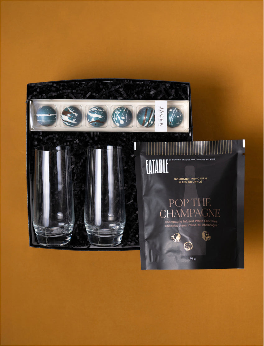 The Cheers gift selection with two champagne glasses, JACEK salted caramels and Eatable Pop the Champagne popcorn.