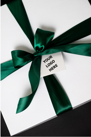 White gift box with green ribbon and a sample logo tag, showing corporate branding options.