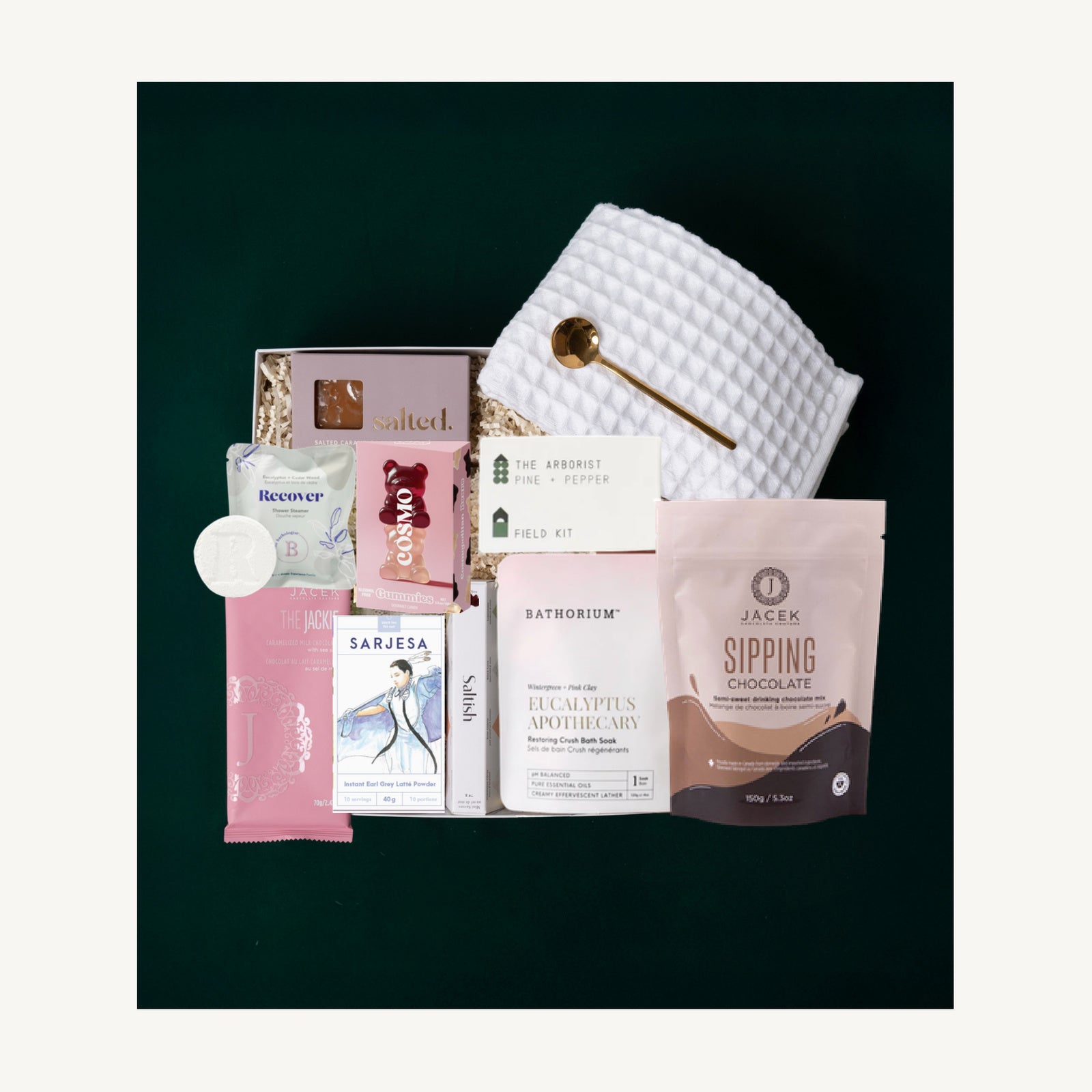 The Luxe Retreat gift selection with a Pokoloko waffle towel, self-care products, a candle, chocolate, caramels and tea latte.