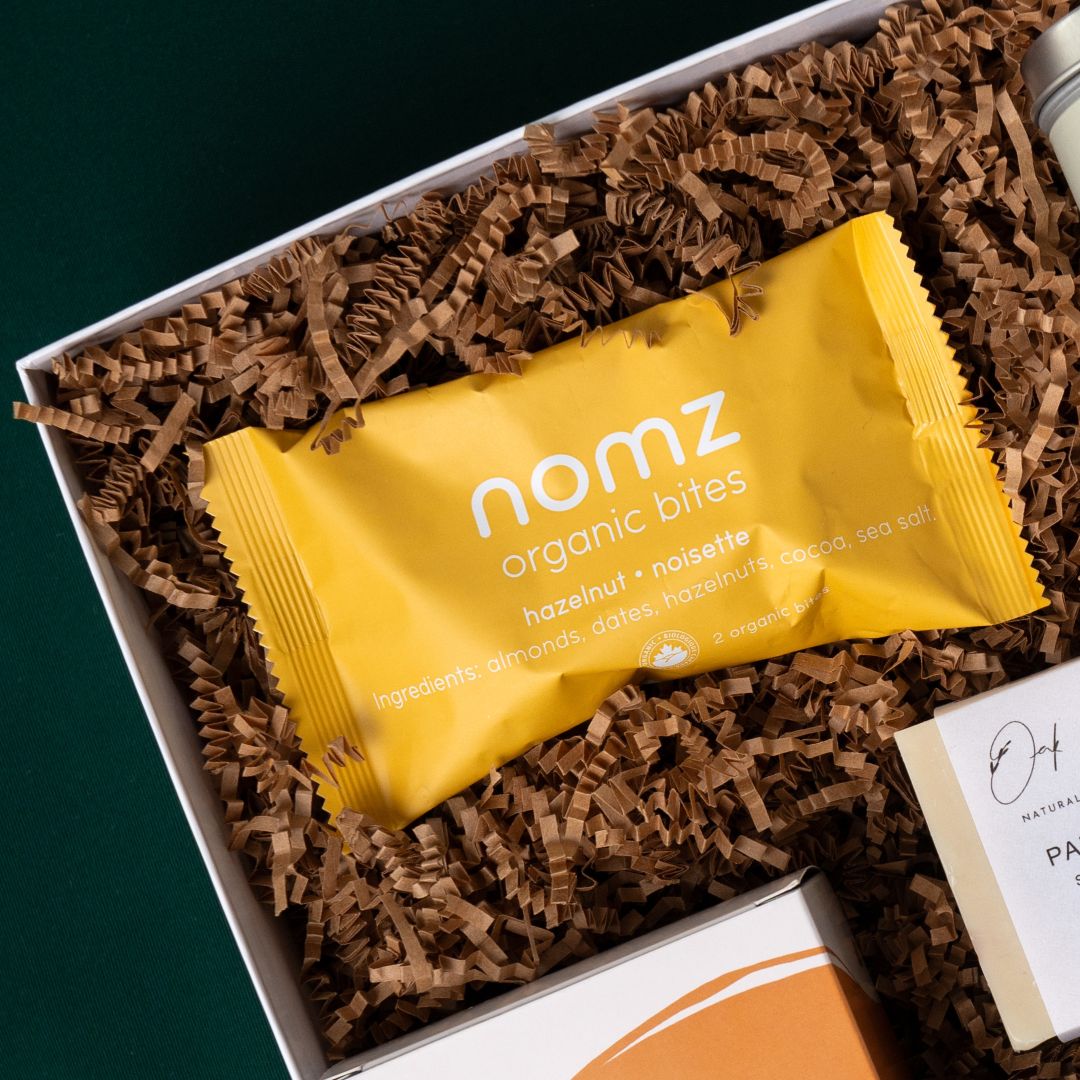 Nomz hazelnut organic date bites in The New Home gift box.